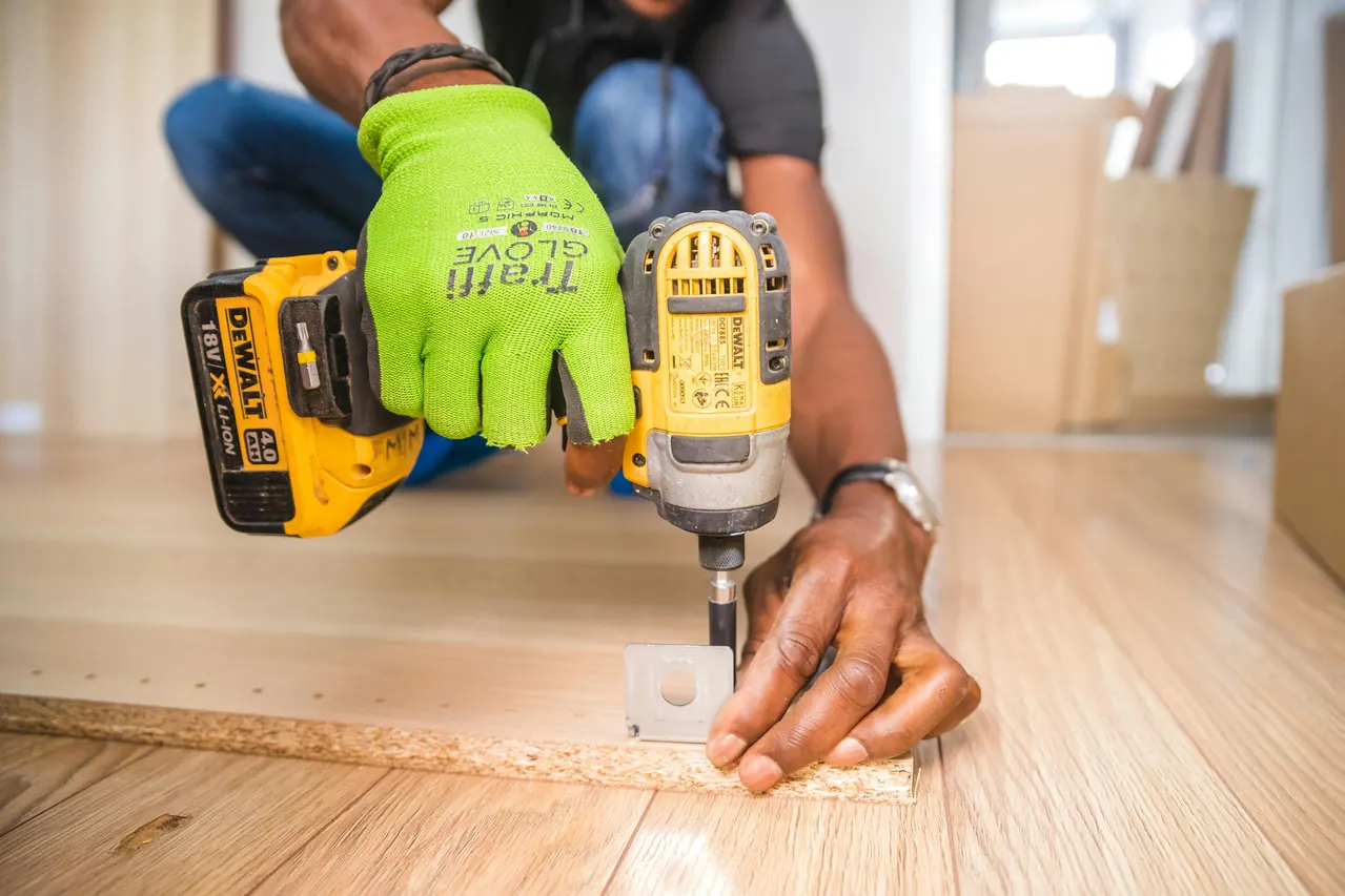 A worker using a drill on a piece of wood