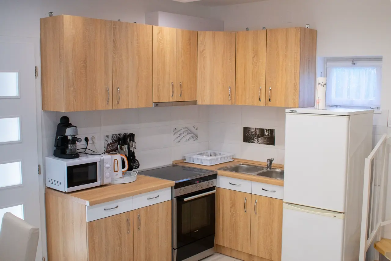 Compact L-shaped kitchen with wood cabinets and space-saving appliance placement